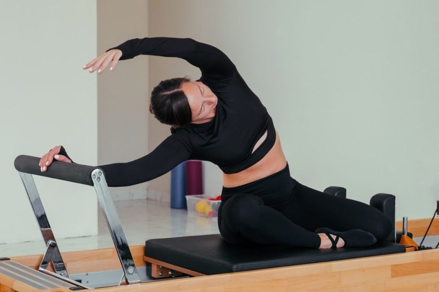 Woman doing Pilates exercise on pilates reformer bed